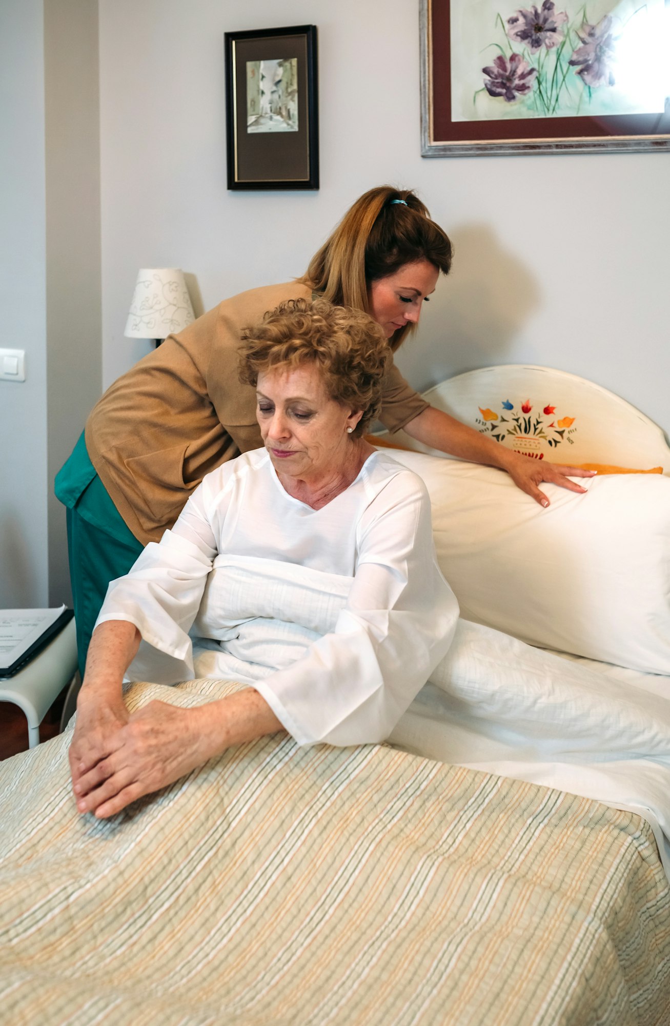 Caregiver accommodating pillow to elderly patient